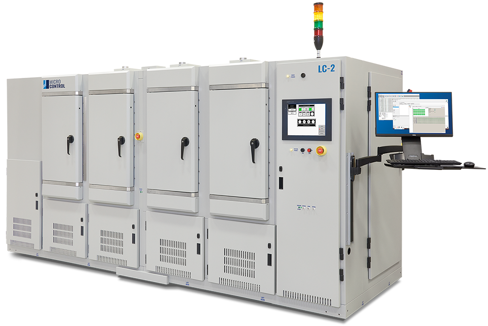 Micro Control LC-2 industrial test system with four storage chambers, a status indicator light stack, and an attached computer workstation.